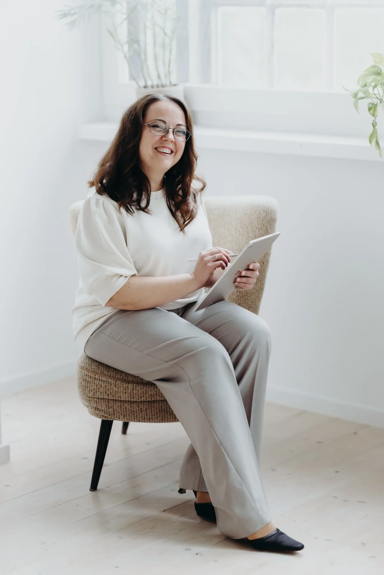 Marina Lübcke sitzt lachend in einem Sessel, in der Hand ein Tablet